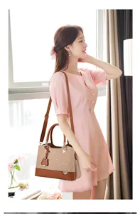 Detail view of large-capacity tote bag with beige geometric pattern and brown leather straps