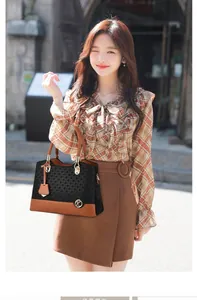 Detail of contrast weave handbag with premium brown leather handle and gold hardware