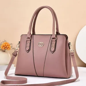 Detail of elegant mauve lychee grain handbag featuring gold buckle and V-shaped stitching