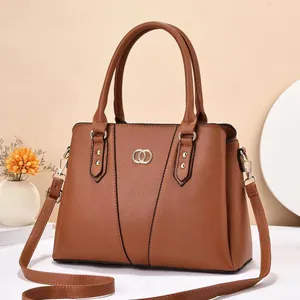 Detail of caramel faux leather tote bag with lychee grain and gold metal hardware