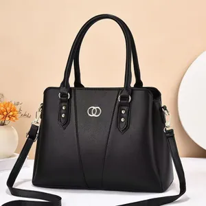 Minimalist black lychee leather handbag with golden ring buckle and detachable shoulder strap