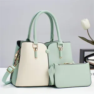 Dettaglio del set di due borse da donna in similpelle verde menta e beige con hardware oro