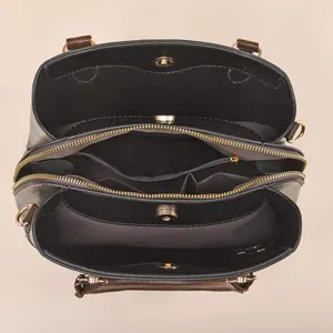 Deep brown leather handbag with multi-layer interior compartments and gold hardware