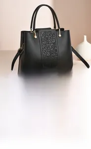 Detail of black tote bag with embossed vintage floral pattern and pearl zipper hardware
