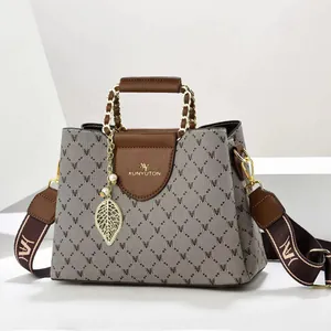Detailansicht der bedruckten Damenhandtasche mit Blattanhänger und Kettenhenkel