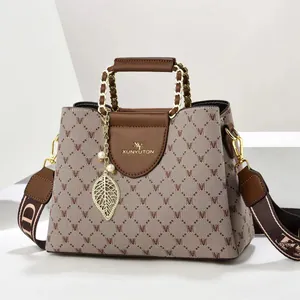 Nahaufnahme der Vintage-Tasche mit Print, Leder und goldenem Blatt-Anhänger
