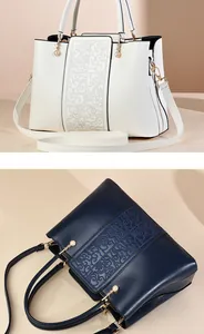 Detail of white and navy leather tote bags with cloud patterns and pearl charms