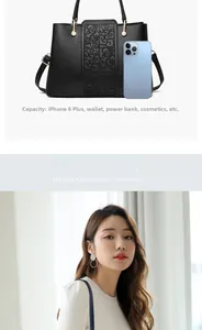 Detailed view of black leather handbag with embossed texture showing large daily capacity
