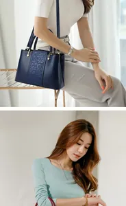 Detail of dark blue leather handbag featuring vintage embroidery and gold metal buckles
