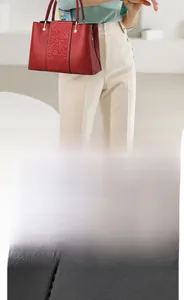 Detailed macro view of red cowhide leather featuring traditional cloud pattern embossing