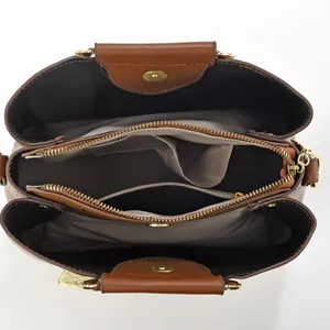 Draufsicht der braunen Lederhandtasche mit drei großen Fächern und goldenen Metall-Reißverschlüssen