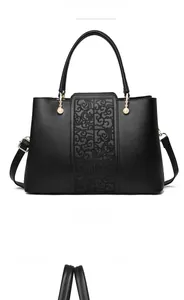 Detail of black crossbody bag with floral embossing, gold hardware and pearl zip charms