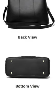 Detail view of the black tote bag showing back, bottom with gold studs and shoulder strap