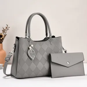 Detail of grey pebbled faux leather tote with diamond stitching and leaf charm