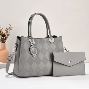 Elegant grey quilted tote bag set with metal leaf pendant and matching envelope clutch