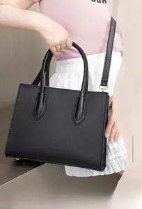 Close-up of black toothpick grain leather texture and metal protective studs on tote bag