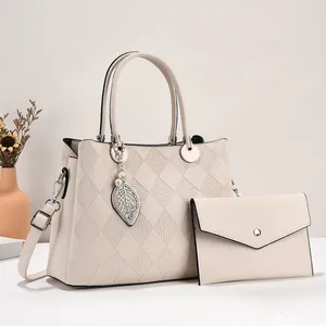 Quilted beige tote bag set with metal leaf pendant and matching envelope clutch