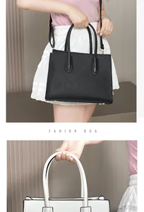 Detail of Saffiano texture tote bag with slim handles and metal base studs