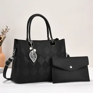Black quilted faux leather tote bag and clutch set with silver leaf pendant accessory
