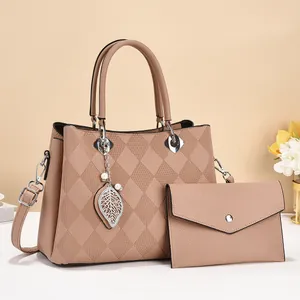 Detail of nude pink faux leather tote bag and pouch set with leaf charm and texture