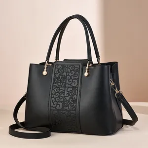 Elegant black tote bag with cloud embroidery, gold hardware, and pearl handle accents