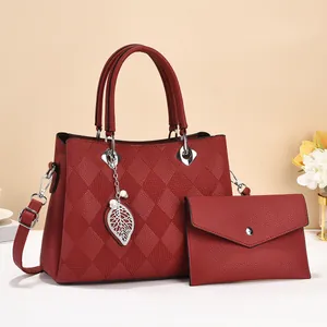 Detail of red quilted tote bag with silver leaf charm and matching envelope pouch