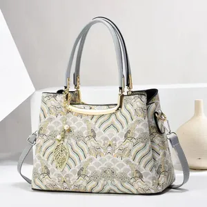 Close-up of jacquard embroidery fabric and gold leaf pendant on a Chinese style handbag