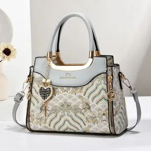 Elegant light blue embroidered handbag with traditional cloud patterns and gold hardware