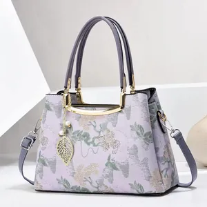 Lilac floral jacquard handbag with golden metal frame and detachable shoulder strap