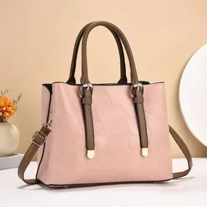 Close-up of pink crossbody tote bag with geometric texture and brown contrast straps