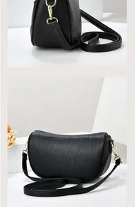 Detail of black pebbled leather half-moon shoulder bag with elegant gold metal hardware