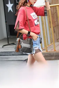 Chic color-block women handbag with brown tassels and long strap shown on model