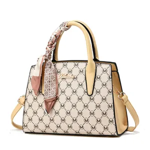 Retro monogrammed beige handbag with black trim, gold logo, and decorative silk scarf