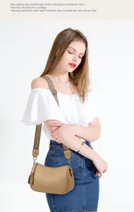 Dettaglio borsa a tracolla in pelle kaki con cinturino jacquard e nappina