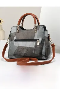 Detail view of the back zipper pocket and patchwork leather design of the handbag