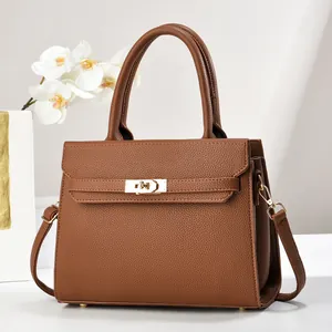 Close-up of brown litchi pattern leather tote bag with elegant gold twist lock hardware