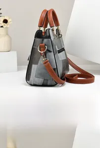 Side view of elegant patchwork handbag with golden hardware and hidden zipper