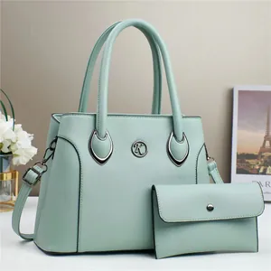 Détail du sac cabas vert menthe à texture grainée avec pochette enveloppe assortie