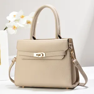 Close-up of beige lychee texture tote with golden twist lock and orchid decoration