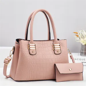 Detailed view of pink crocodile embossed handbag set with gold hardware and strap