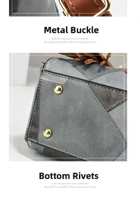 Detail of gray handbag showing golden hardware buckle, bottom studs and stitching