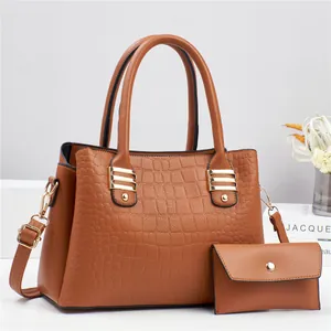 Brown crocodile embossed tote bag and matching purse set with gold hardware on display