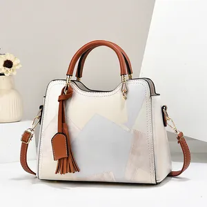 Fashionable paneled leather handbag for middle-aged women with top handles and tassel charm