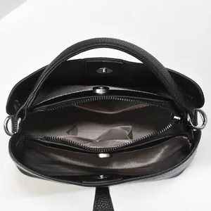 Macro view of bucket bag interior showing three compartments with zip and magnetic closure