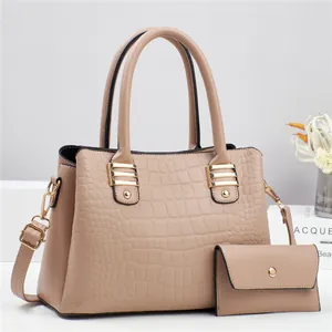 Detailed macro view of beige faux crocodile leather handbag and matching long wallet set