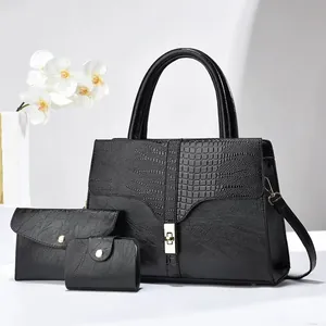 Detailed view of 3-piece black leather handbag set with croc-embossed texture and gold lock