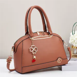 Borsa a conchiglia marrone in pelle martellata con ciondoli quadrifoglio e finiture oro