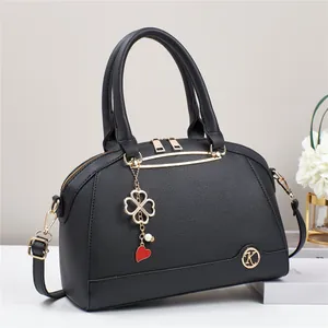 Elegante borsa a tracolla nera a conchiglia con dettagli dorati e ciondolo alla moda