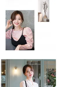 Detail view of pink puff sleeve top and white V-neck shirt in a modern fashion style