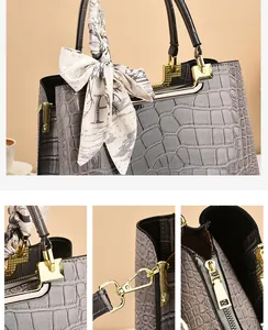 Dettagli della borsa a secchiello grigia goffrata coccodrillo con hardware dorato e foulard